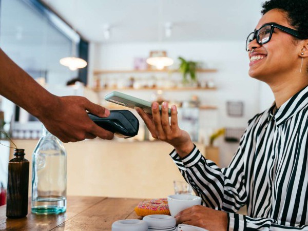 Woman paying for coffee using her phone